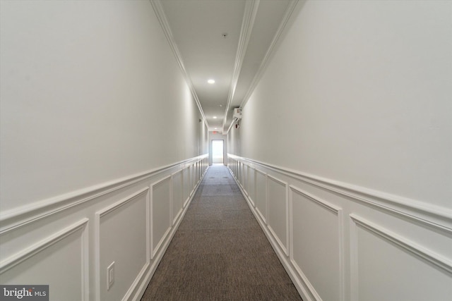 hall with ornamental molding and dark carpet