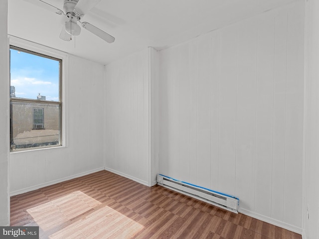 unfurnished room with ceiling fan, hardwood / wood-style flooring, and baseboard heating