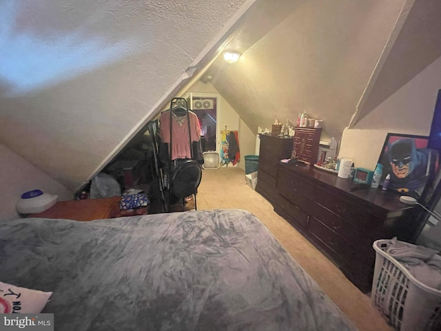 bedroom with a textured ceiling, light colored carpet, and lofted ceiling