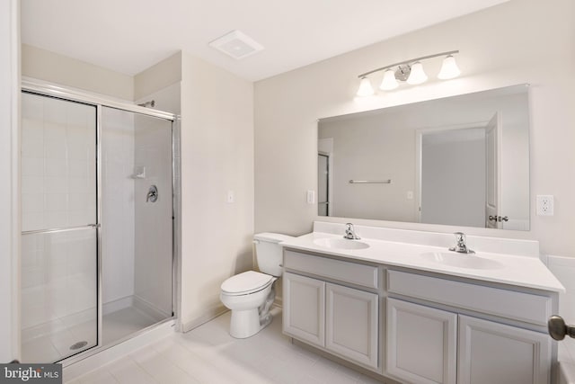 bathroom with tile floors, a shower with door, toilet, and dual bowl vanity