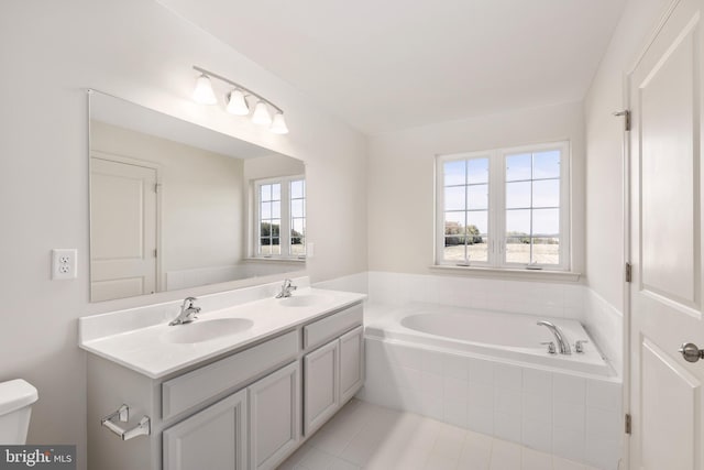 bathroom with tile floors, toilet, dual vanity, and a wealth of natural light