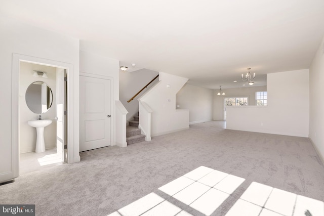 interior space with light carpet, sink, and an inviting chandelier