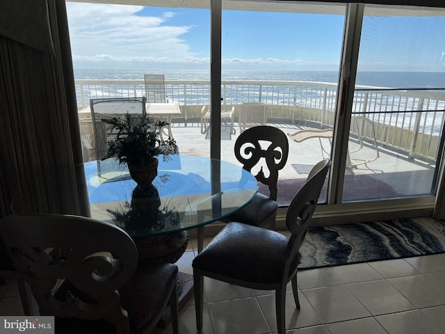 tiled dining room with a water view and a beach view