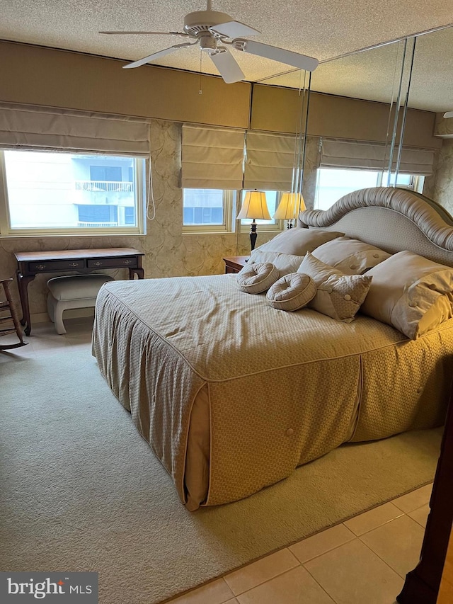 bedroom featuring ceiling fan, a textured ceiling, and carpet flooring