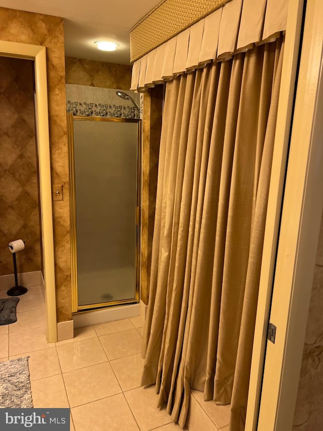 bathroom with a shower with shower curtain and tile patterned floors