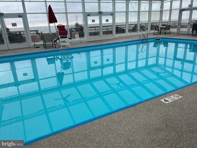 community pool with glass enclosure and a patio