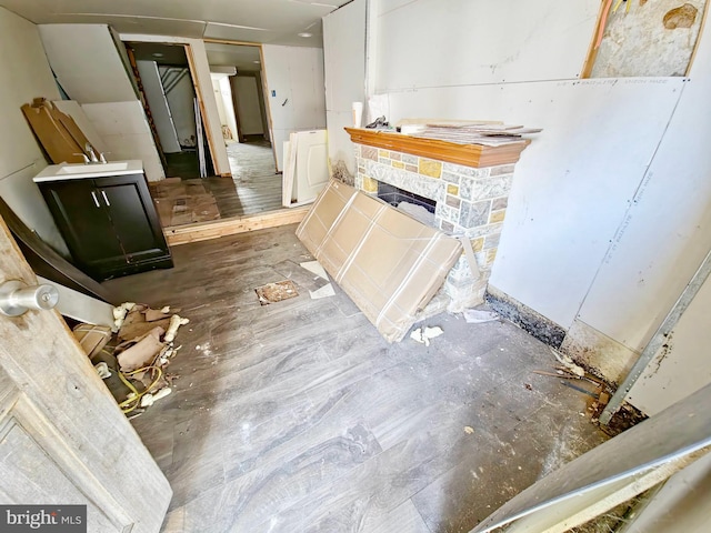 bathroom featuring washer / clothes dryer, sink, hardwood / wood-style floors, and a stone fireplace