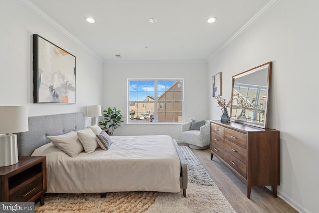 bedroom with light hardwood / wood-style floors and crown molding