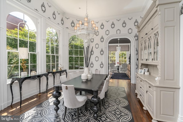 dining room featuring crown molding, a notable chandelier, and dark hardwood / wood-style flooring