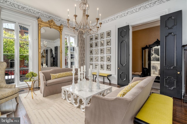 sitting room featuring an inviting chandelier, hardwood / wood-style floors, and crown molding