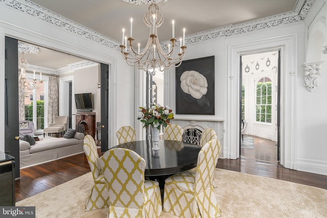 dining room featuring a healthy amount of sunlight, dark wood-type flooring, a notable chandelier, and ornamental molding