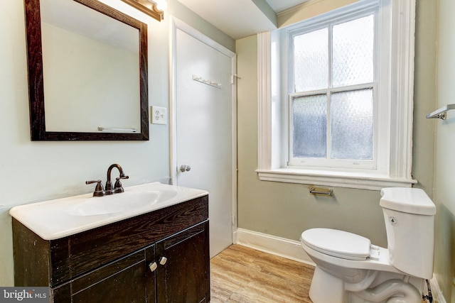 bathroom with hardwood / wood-style flooring, vanity, and toilet