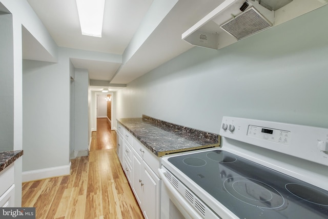 kitchen featuring dark stone countertops, white cabinetry, white electric range oven, and light hardwood / wood-style floors