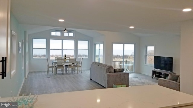 living room featuring ceiling fan, lofted ceiling, plenty of natural light, and dark hardwood / wood-style floors