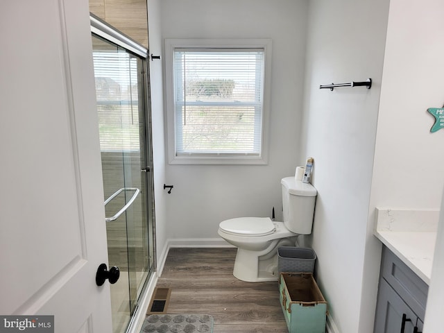 bathroom with toilet, a wealth of natural light, vanity, and wood-type flooring