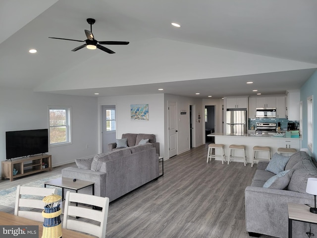 living room with high vaulted ceiling, light hardwood / wood-style floors, and ceiling fan