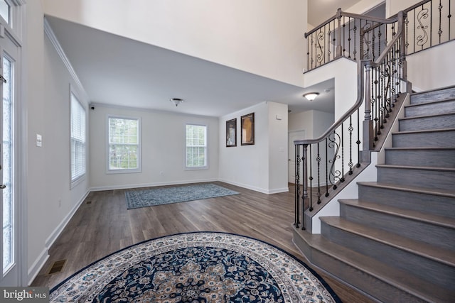 foyer entrance featuring ornamental molding and dark hardwood / wood-style flooring