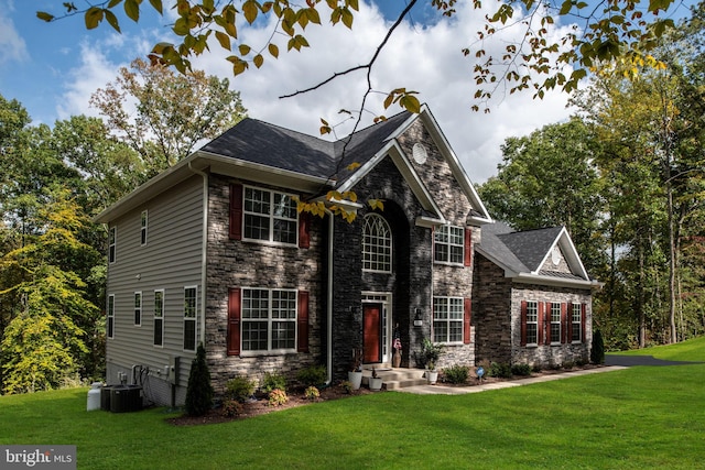 colonial inspired home featuring cooling unit and a front lawn