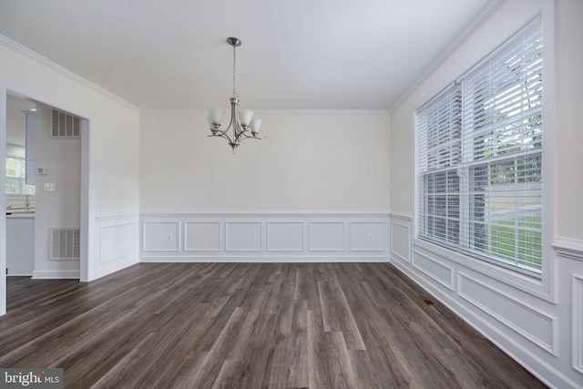 spare room with dark wood-type flooring, a notable chandelier, and crown molding