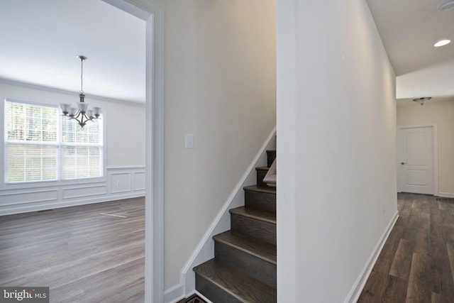 stairs with an inviting chandelier and hardwood / wood-style floors