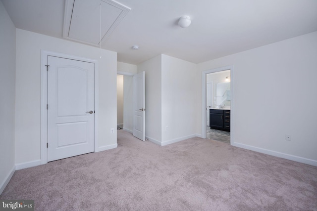 unfurnished bedroom featuring ensuite bath and light colored carpet