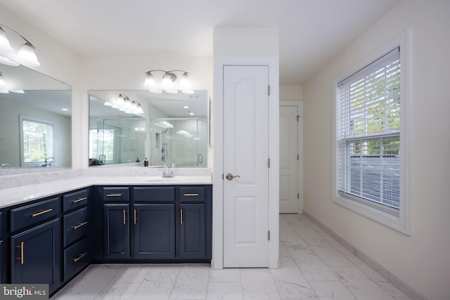 bathroom with vanity, a healthy amount of sunlight, and a shower with door