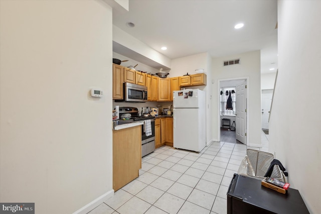 kitchen featuring stainless steel appliances and light tile patterned flooring