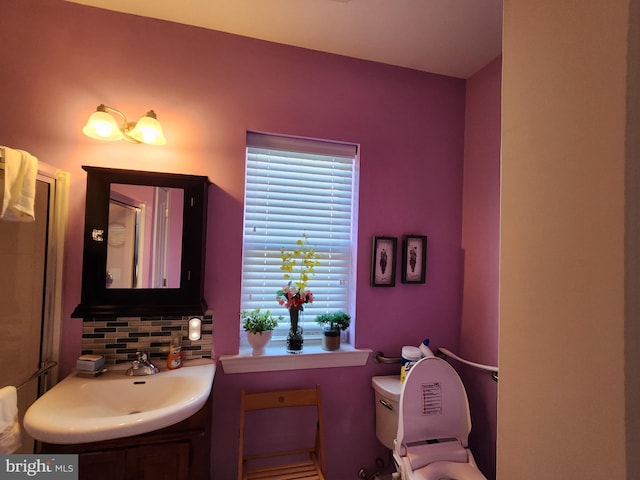 bathroom featuring backsplash, toilet, and vanity