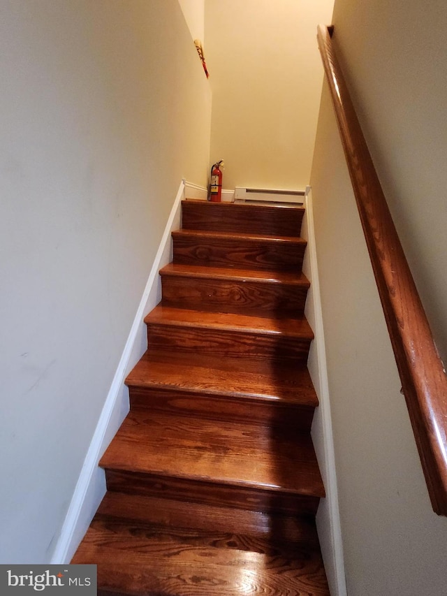 staircase with a baseboard heating unit