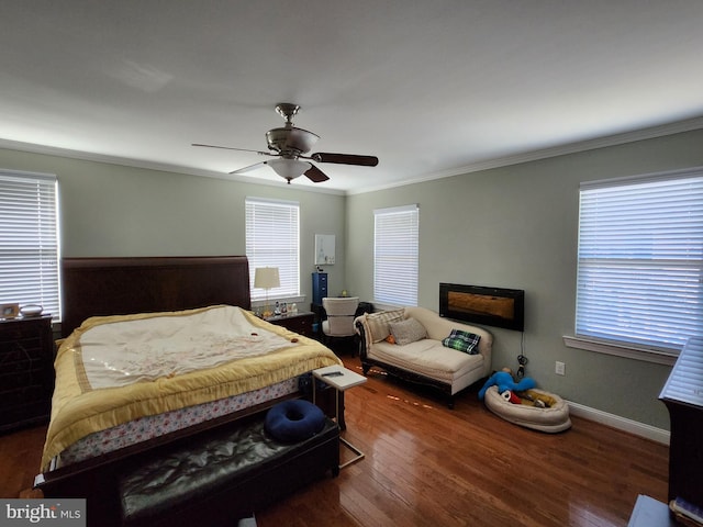 bedroom with a fireplace, ornamental molding, ceiling fan, and dark hardwood / wood-style flooring