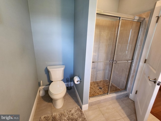 bathroom featuring toilet, tile floors, and a shower with shower door