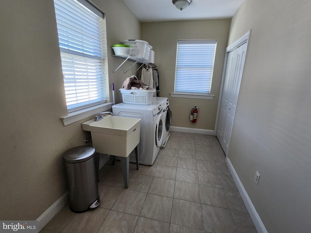 laundry room with washing machine and dryer and light tile floors