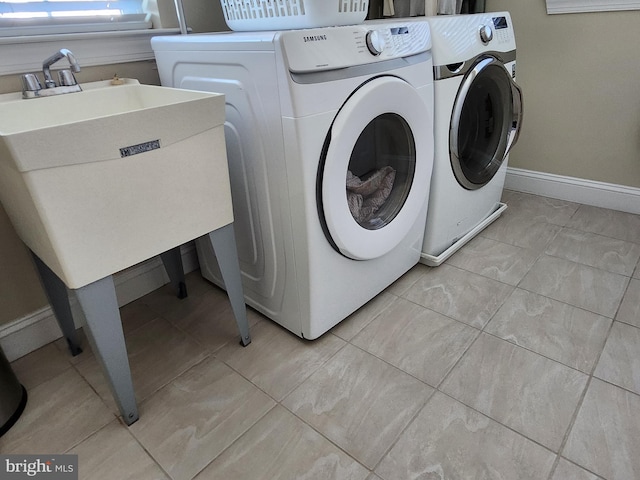 laundry area with independent washer and dryer and light tile floors