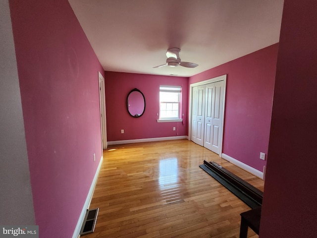 spare room with ceiling fan and light wood-type flooring