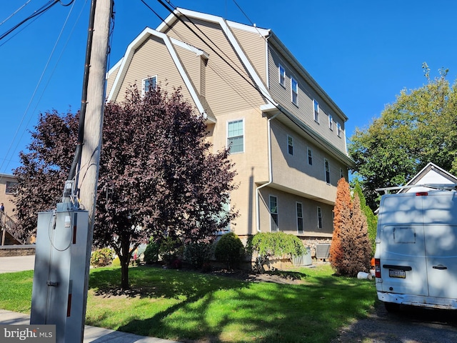 view of side of home with a yard