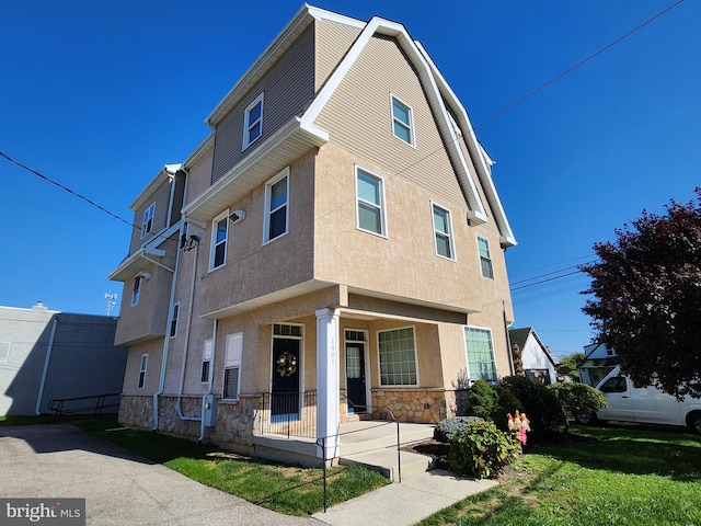 townhome / multi-family property with a front yard