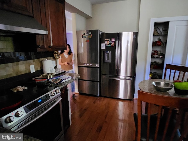 kitchen featuring stainless steel appliances, dark brown cabinets, and dark hardwood / wood-style floors