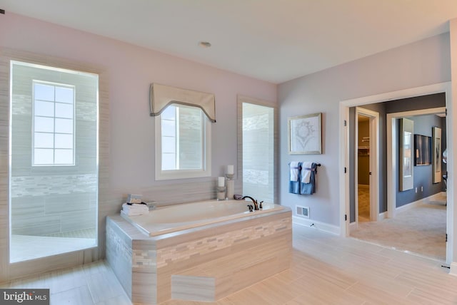 bathroom featuring tile floors and a relaxing tiled bath