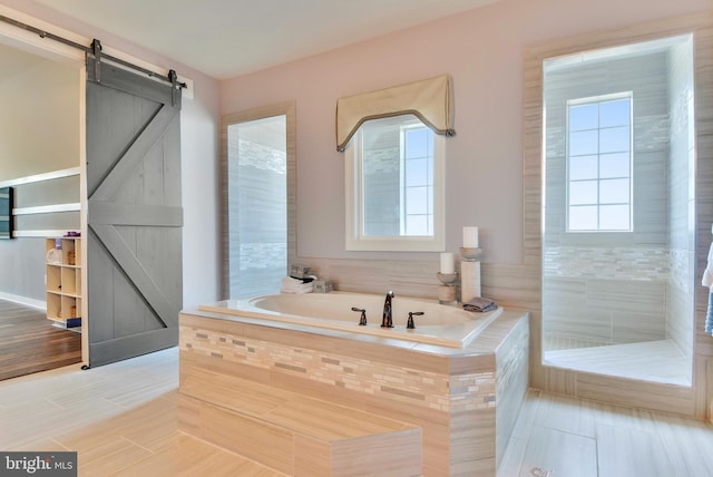 bathroom with tiled bath, tile flooring, and a wealth of natural light