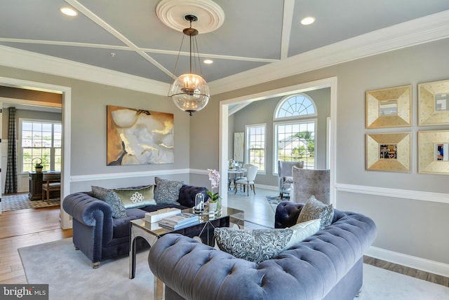 living room featuring an inviting chandelier, crown molding, and light hardwood / wood-style flooring