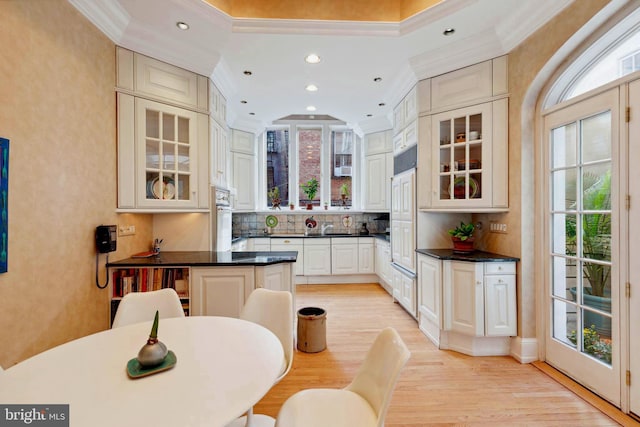 kitchen featuring oven, light hardwood / wood-style flooring, a breakfast bar, and tasteful backsplash