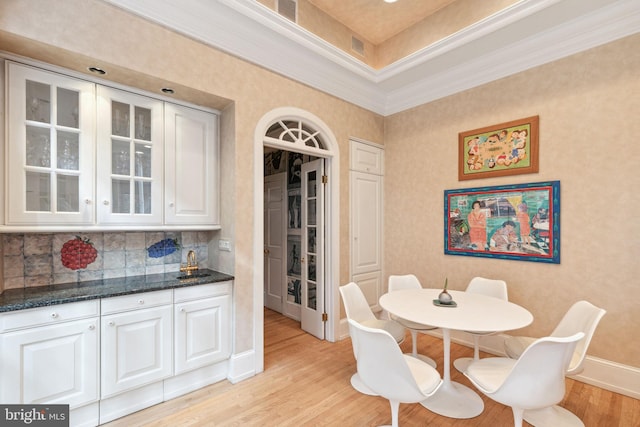 dining area featuring light hardwood / wood-style floors, sink, and ornamental molding