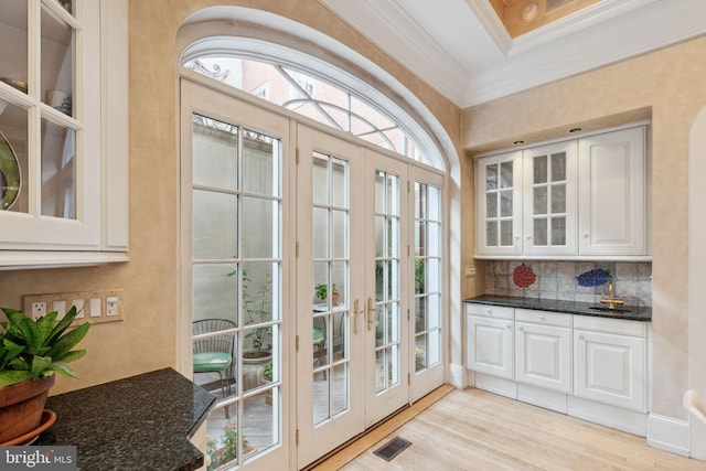 doorway featuring crown molding, french doors, a healthy amount of sunlight, and light hardwood / wood-style flooring