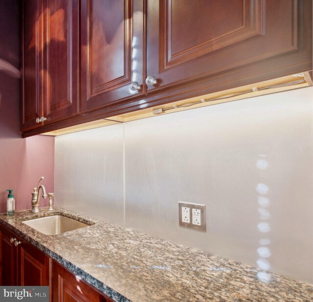 kitchen featuring dark stone counters and sink