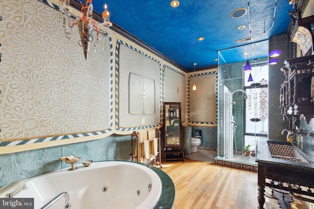 bathroom featuring hardwood / wood-style floors, a bathtub, crown molding, and toilet