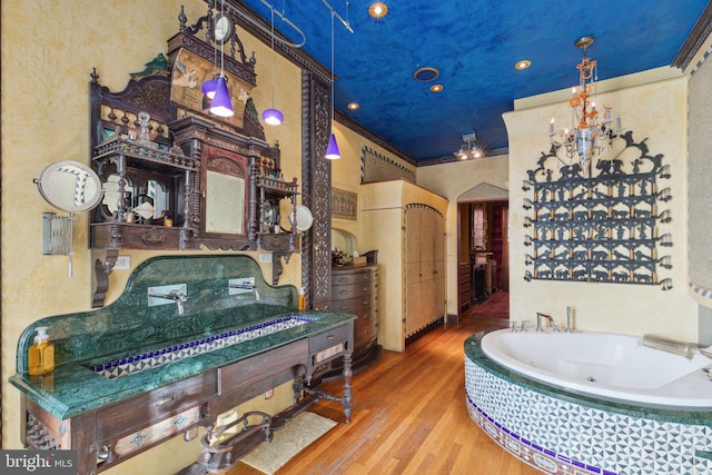 interior space featuring tiled bath, vanity with extensive cabinet space, ornamental molding, and hardwood / wood-style flooring