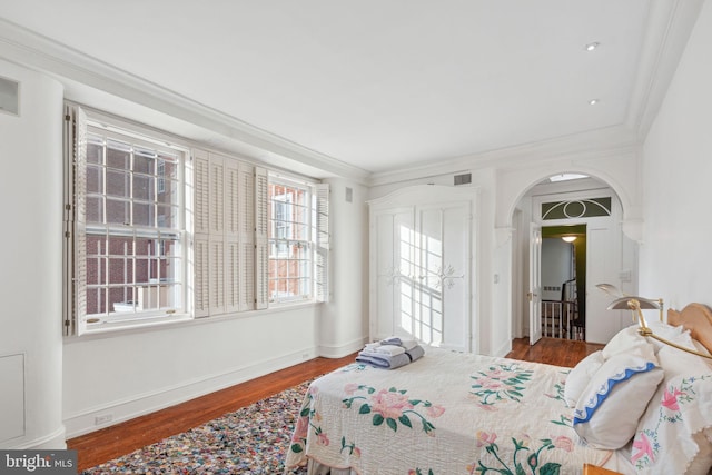 bedroom with crown molding and dark hardwood / wood-style flooring