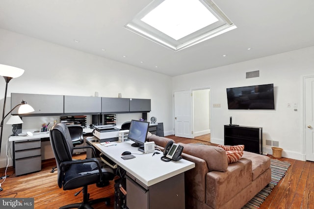 home office featuring a skylight and light wood-type flooring