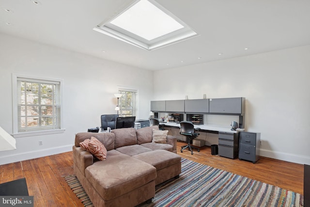 living room with light wood-type flooring and a skylight