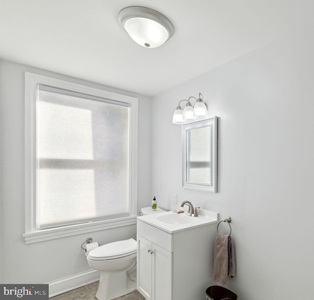 bathroom with toilet, tile flooring, and vanity